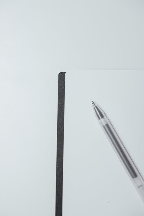 Close-Up Shot of a Notebook and a Pen