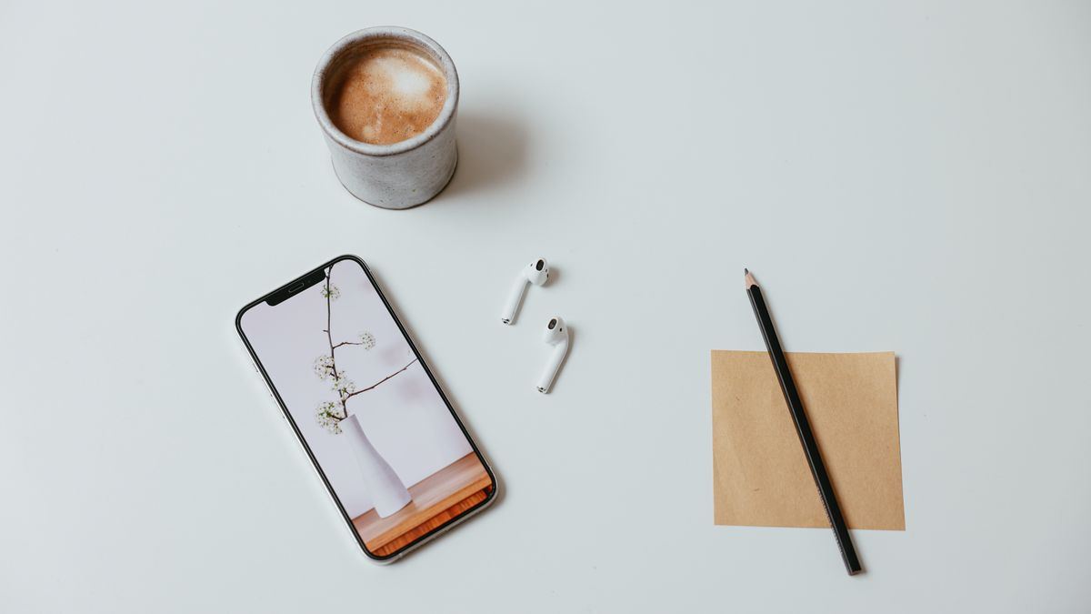 スマートフォンとイヤホン、メモ用紙を並べた英会話練習の準備イメージ
