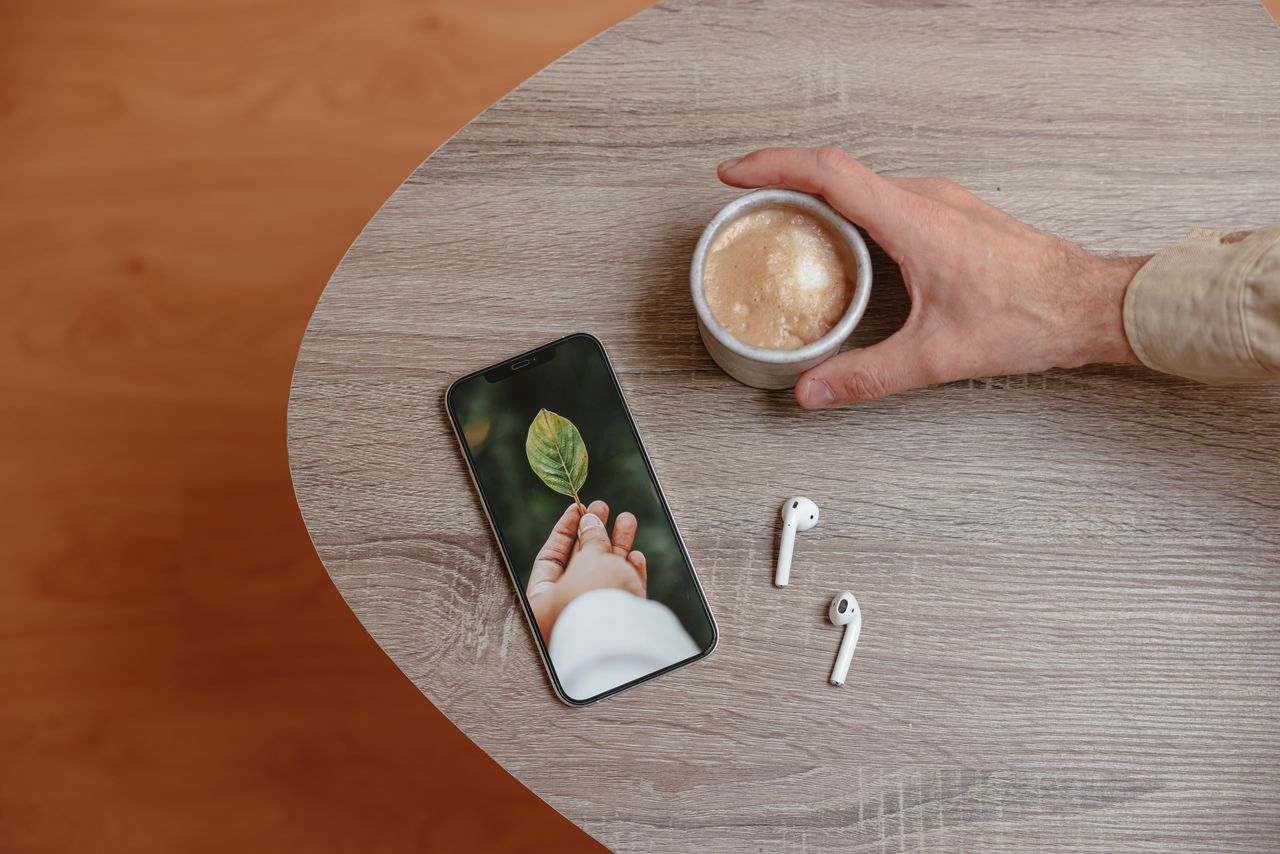 stylish workspace with coffee smartphone and earphones on a wooden des