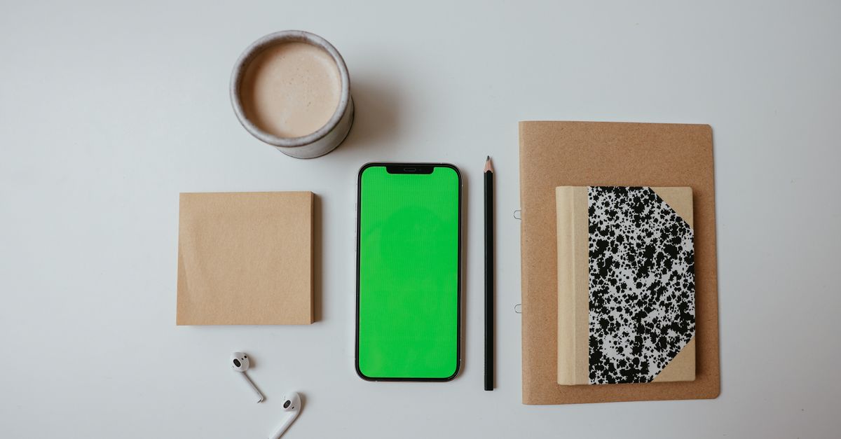 A messy desk with a coffee cup, a notepad with