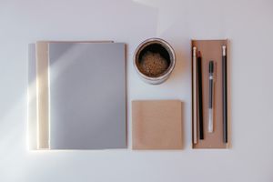 Notebook and pens laid out on a desk — photo by Cup of Couple on Pexels