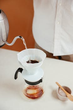 Elegant pour-over coffee being prepared with a kettle and filter.