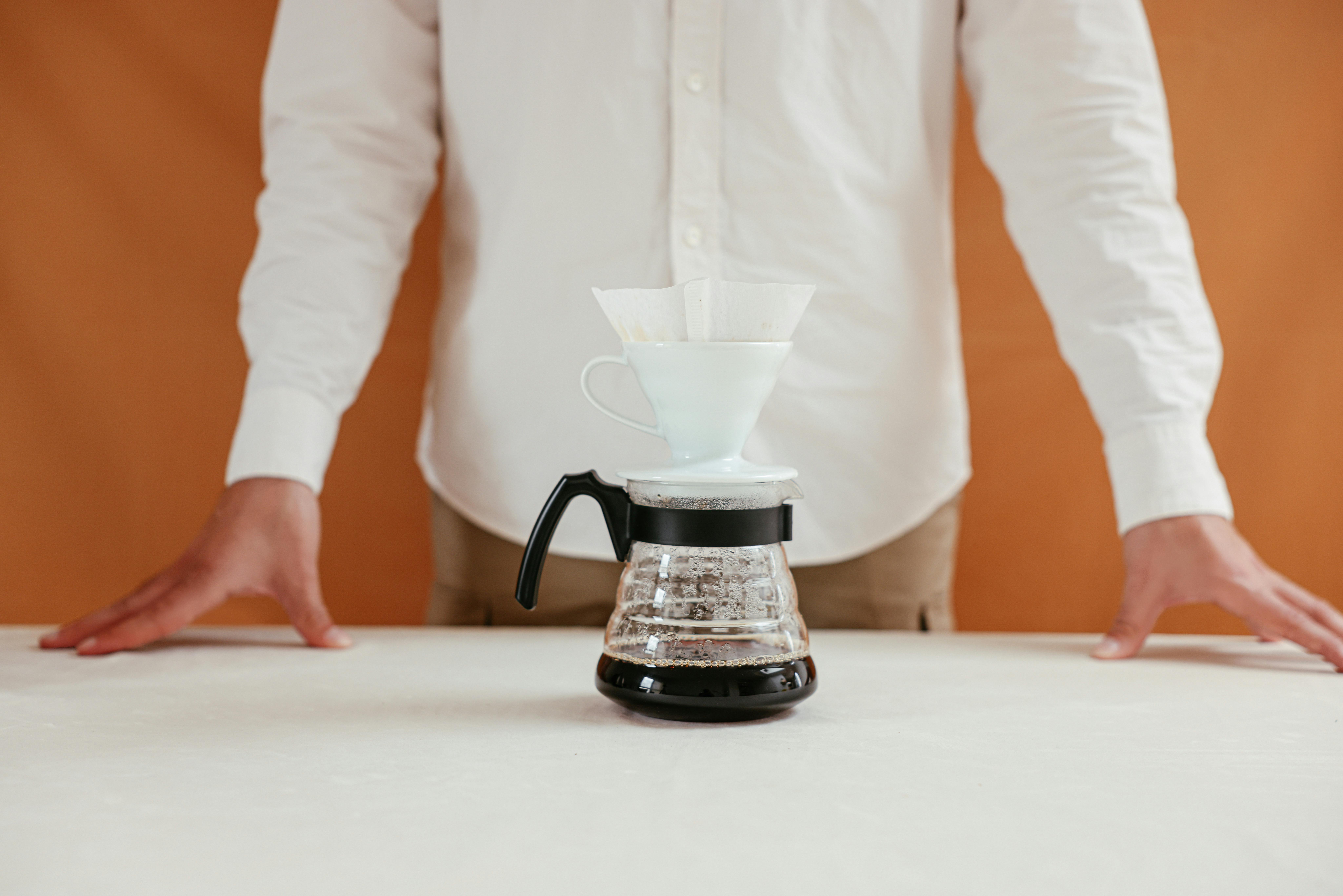 Person making pour-over coffee with a dripper