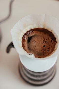 Close-up of a steaming pour over coffee in a dripper, rich in aroma and texture.