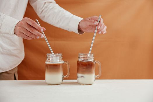 Person Holding Silver Spoon and Clear Glass Jar