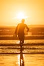 Silhouette of Man Standing on Beach during Sunset