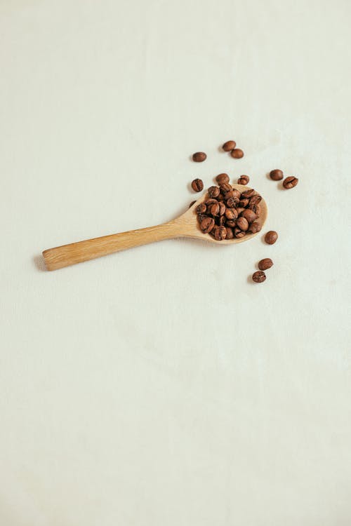 Close-Up Shot of Coffee Beans on a Wooden Spoon