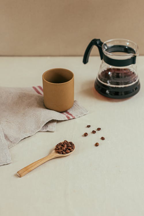 Free Coffee Beans on Wooden Spoon Near Table Napkin Stock Photo