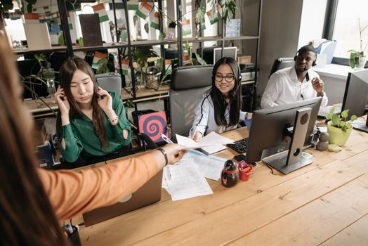 Diverse call center team collaborating at a modern workspace, showcasing teamwork and communication.