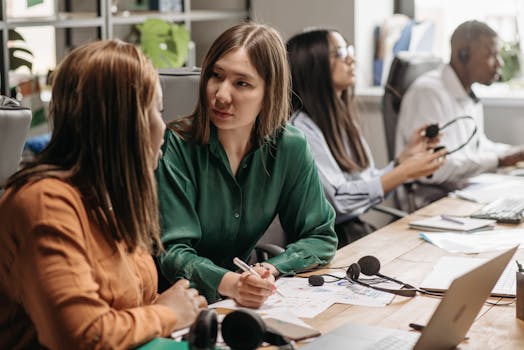 A diverse group of colleagues engaging in teamwork at a modern office workspace.
