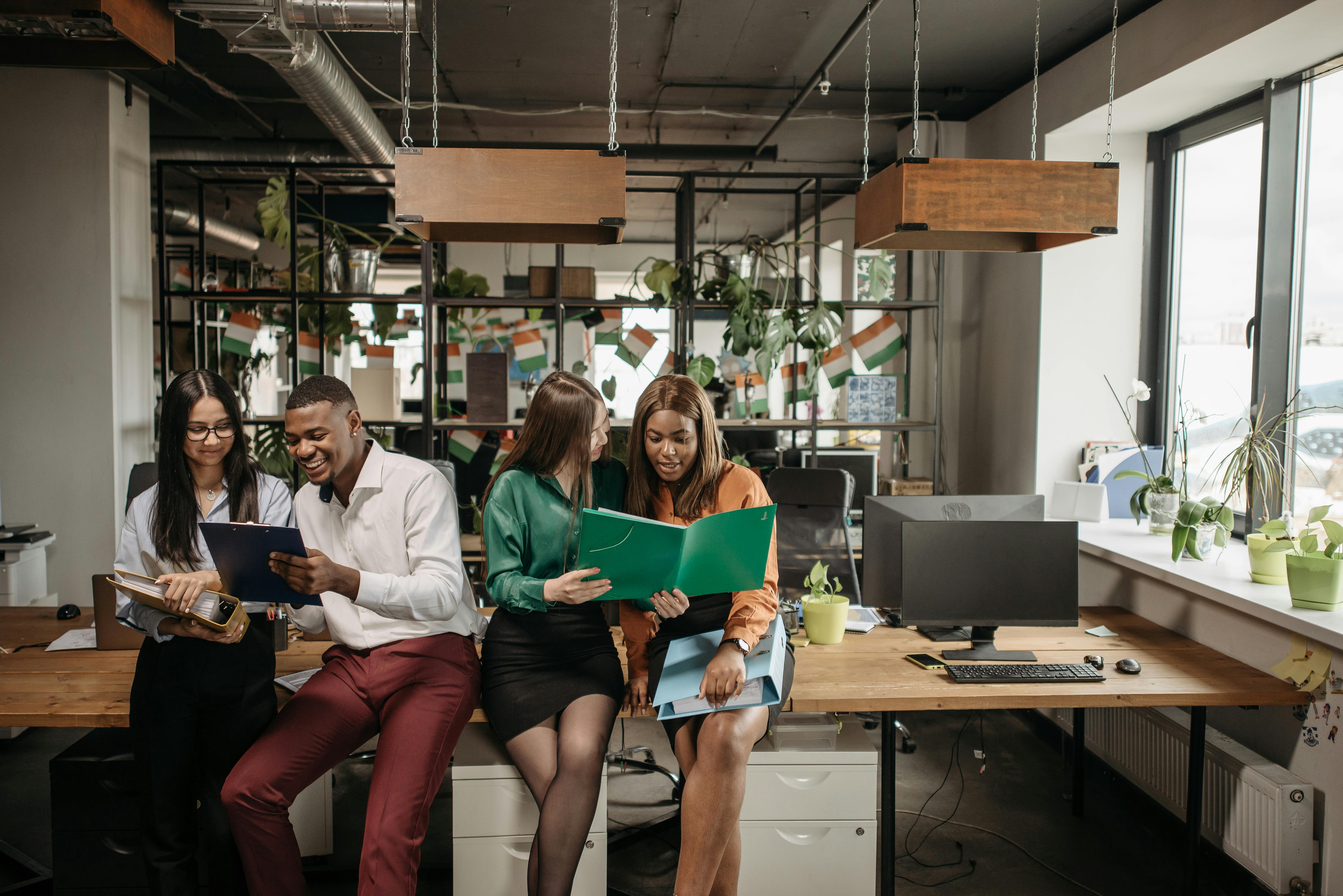 Group of colleagues sharing ideas in a vibrant office environment, promoting team collaboration and diversity.