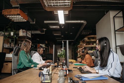 Free A mixed-gender team working at a call center desk, focusing on customer service tasks. Stock Photo