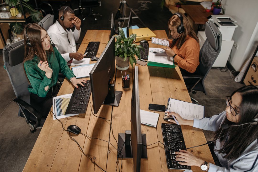 Diverse team of customer service representatives working collaboratively in a modern office environment.