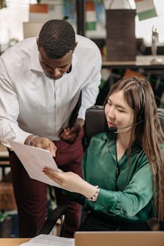 Two colleagues discussing a document in a modern office, reflecting teamwork and communication.
