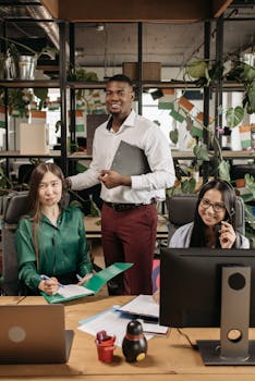 A diverse team of colleagues collaborating in a modern office setting, smiling and working together.