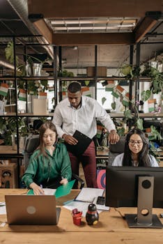 Diverse colleagues working together in a modern, plant-filled office environment.