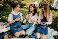 Women Sitting on Green Grass Field