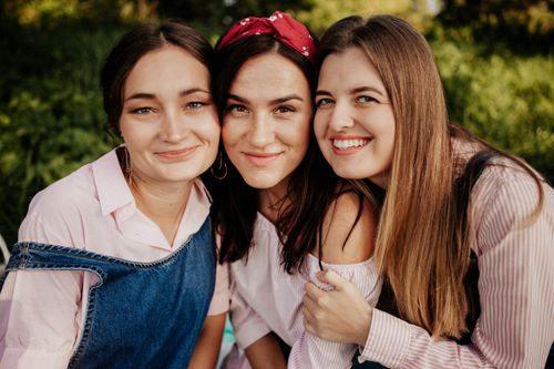 Free Three women enjoying a sunny day outdoors with joyful smiles. Stock Photo