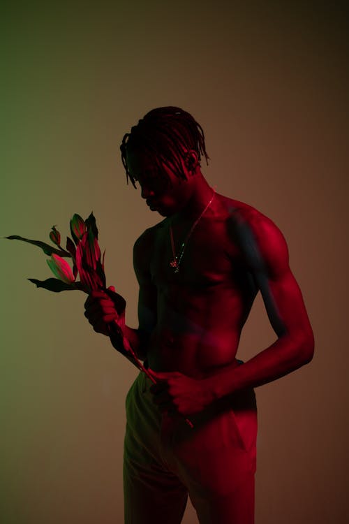 A Shirtless Man Holding Flowers
