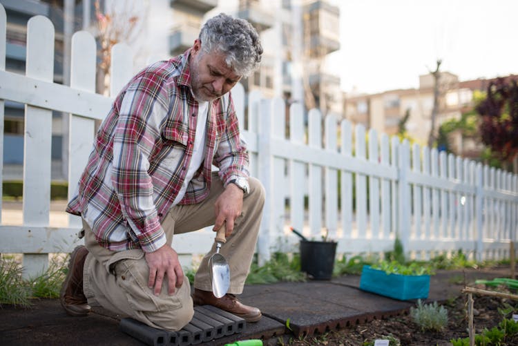 Elderly Man Holding A Trowel