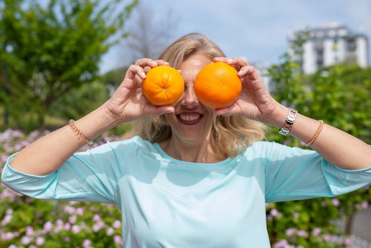 Woman Covering Eyes With Oranges