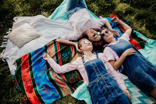 Women Lying Down on Blanket on Grass