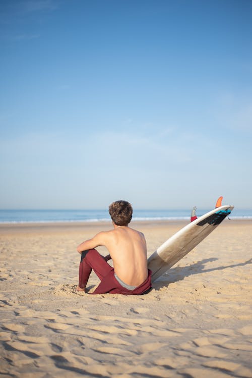 Free A Person Sitting on the Sand Stock Photo