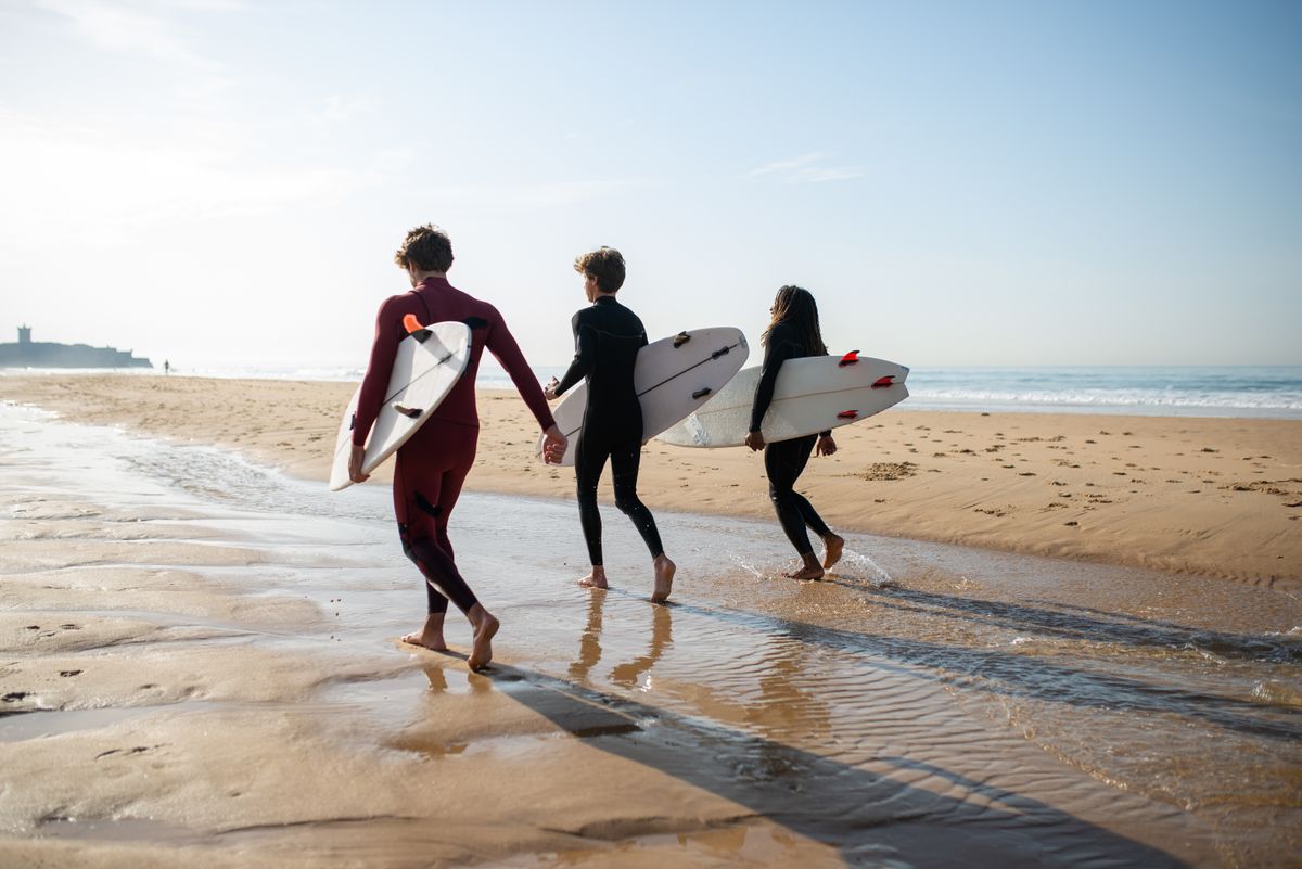 Surfistas caminando hacia el mar con sus tablas