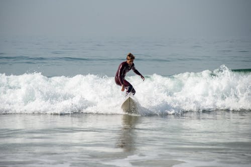 Free A Man Surfing at the Beach Stock Photo