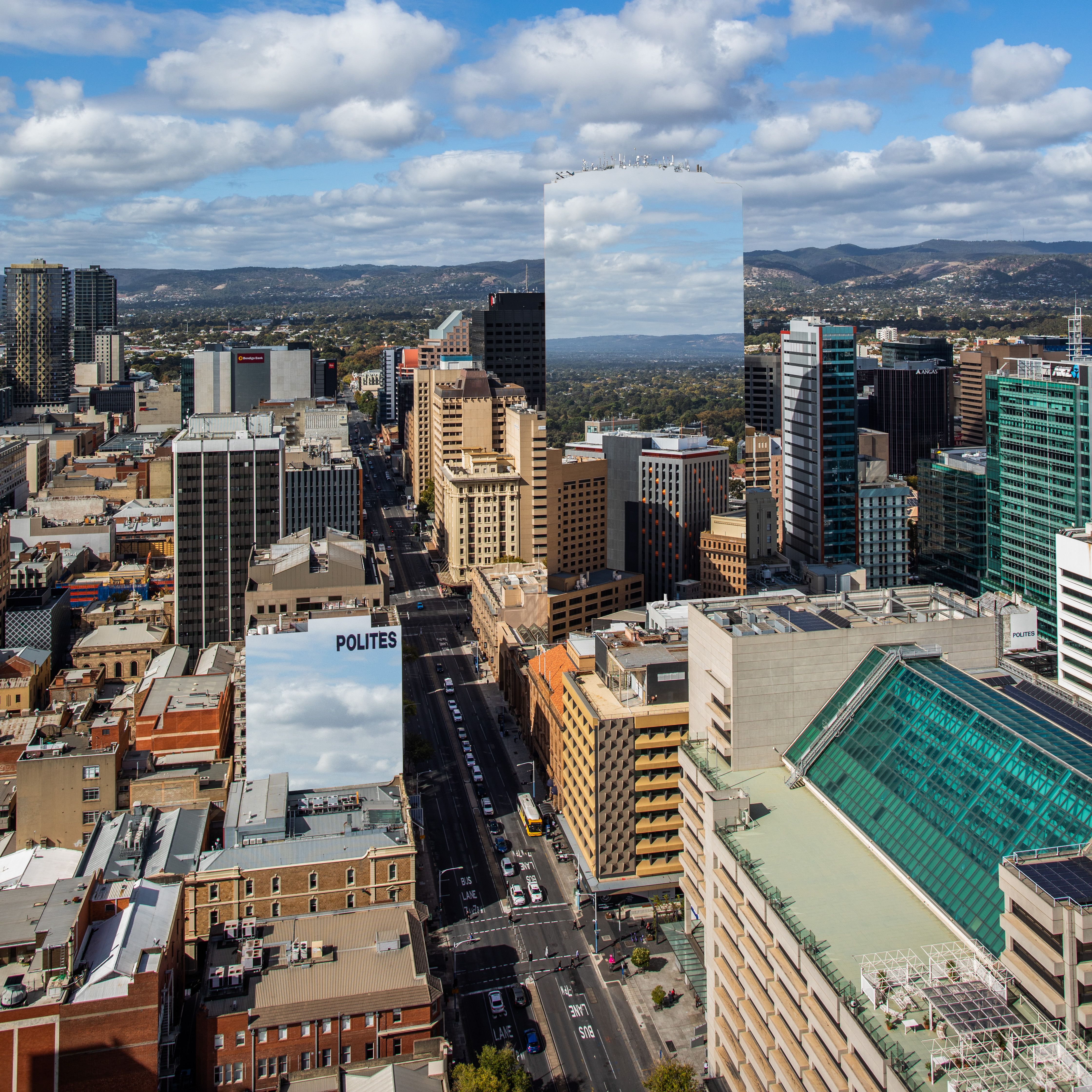 A breathtaking aerial view of Adelaide cityscape featuring mirrored skyscrapers reflecting the vibrant skyline.