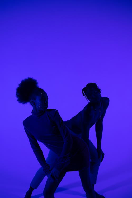 Woman and Man Posing on Blue Background