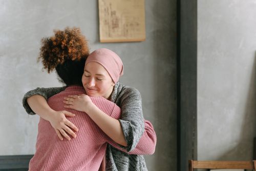 Free Two women embracing each other with warmth and love, symbolizing support and care indoors. Stock Photo