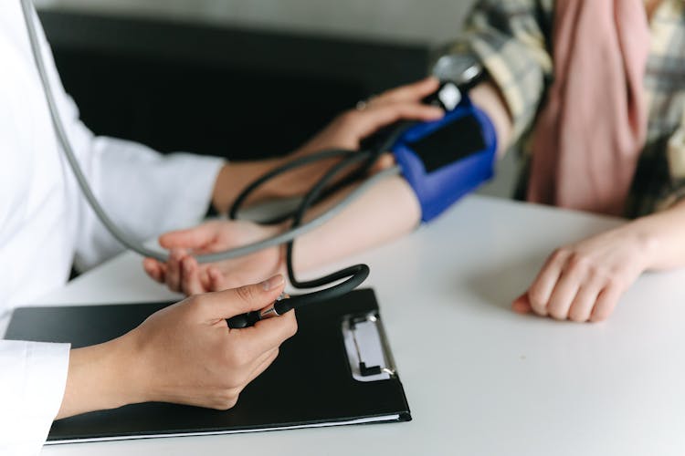 A Healthcare Worker Measuring A Patient's Blood Pressure Using A Sphygmomanometer