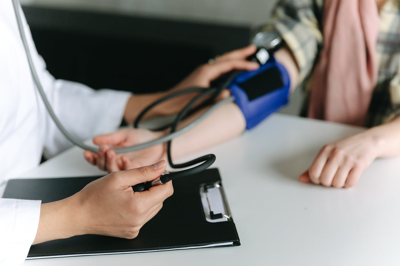 Operatore sanitario misura la pressione arteriosa del paziente con sfigmomanometro