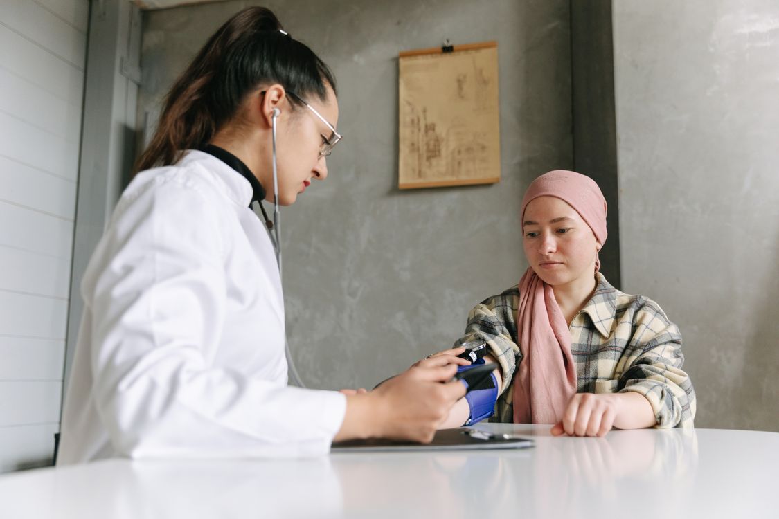 Dokter memeriksa tekanan darah pasien perempuan