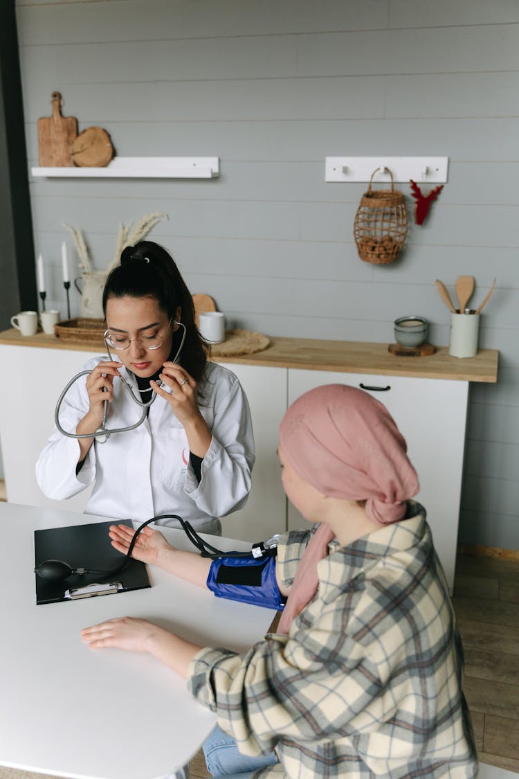 A Woman Checking Blood Pressure Of Her Patient