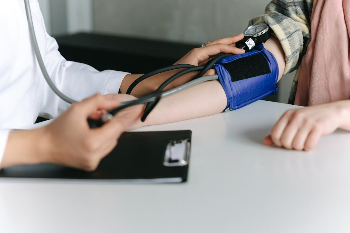 Free A Healthcare Worker Measuring a Patient's Blood Pressure Using a Sphygmomanometer Stock Photo