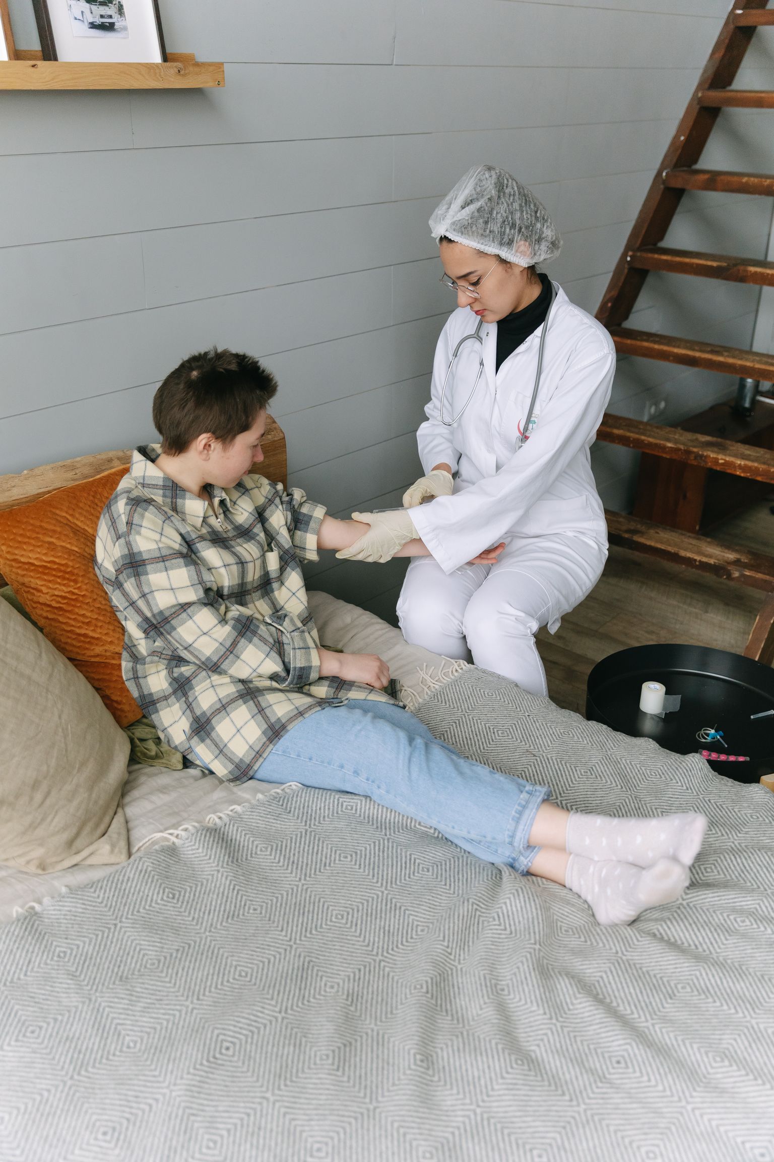 Healthcare professional supporting a patient's arm during a home visit