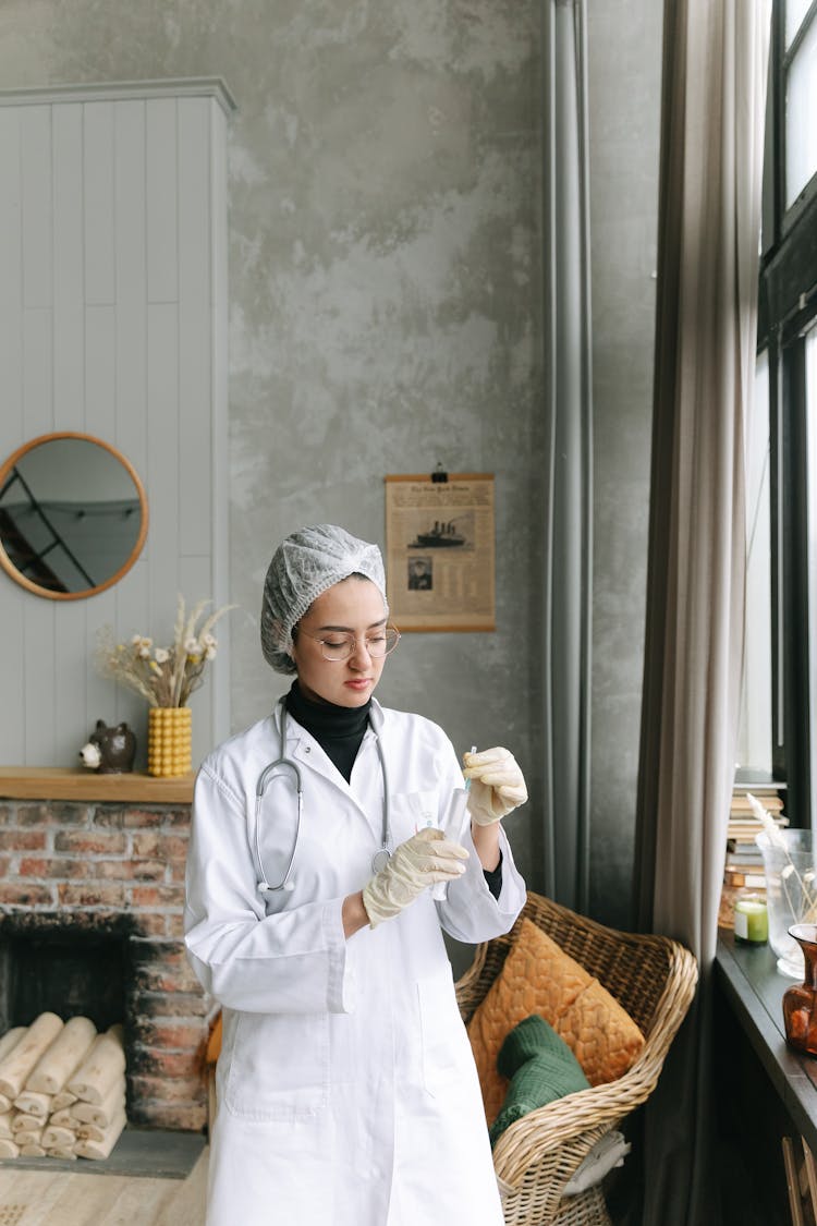 A Doctor Holding A Syringe Indoors