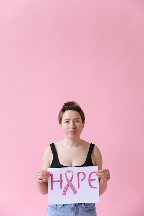 A Woman in Black Tank Top Holding a Hope Sign Symbol for Breast Cancer