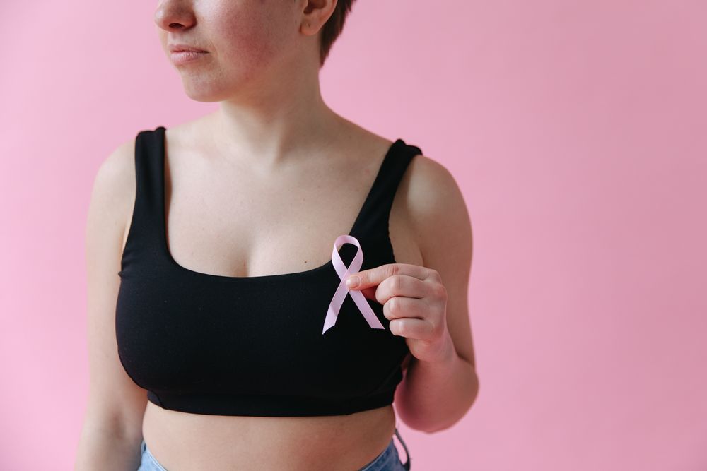 Primer pla de mans que sostenen un llaç rosa de sensibilització