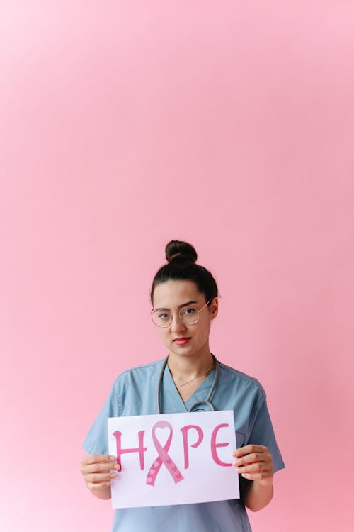 A Doctor Holding a Sign for Breast Cancer Awareness