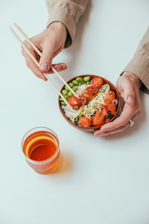 Free Person Holding a Rice Bowl and Chopsticks Stock Photo