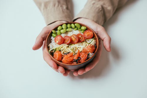 Person Holding a  Rice Bowl with Toppings