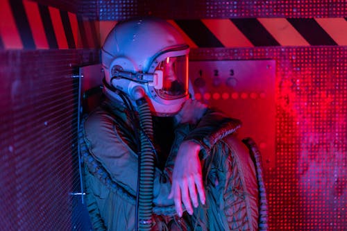 Side View Of Woman In Spacesuit Sitting Near A Control Panel 