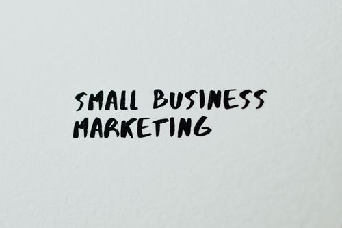 Free Text 'Small Business Marketing' written on white paper for creative use. Stock Photo