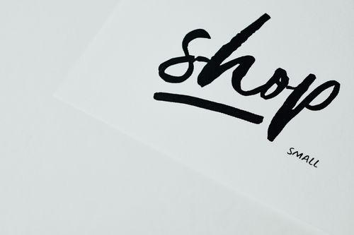 Free Elegant handwritten 'shop' sign on white background, perfect for retail design. Stock Photo