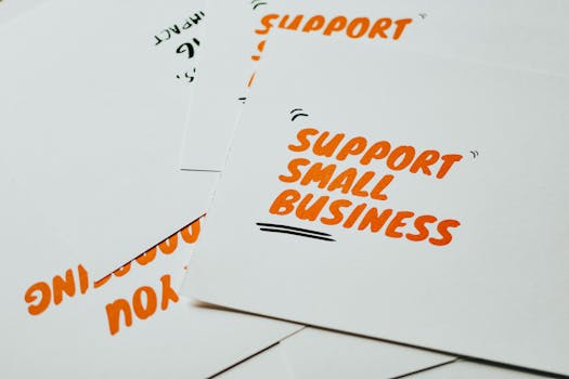 Close-up of motivational cards promoting support for small business on white background.