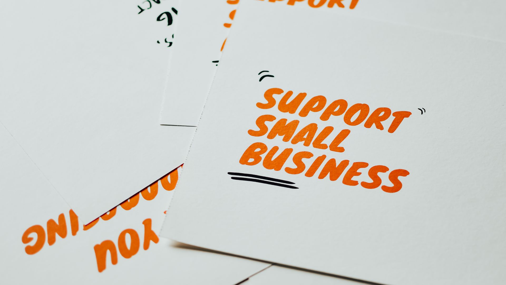 Business Cards: Your Ultimate Networking Tool 4 Close-up of motivational cards promoting support for small business on white background — business cards