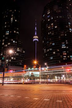 Captivating Toronto cityscape featuring the illuminated CN Tower at night with dynamic light trails.